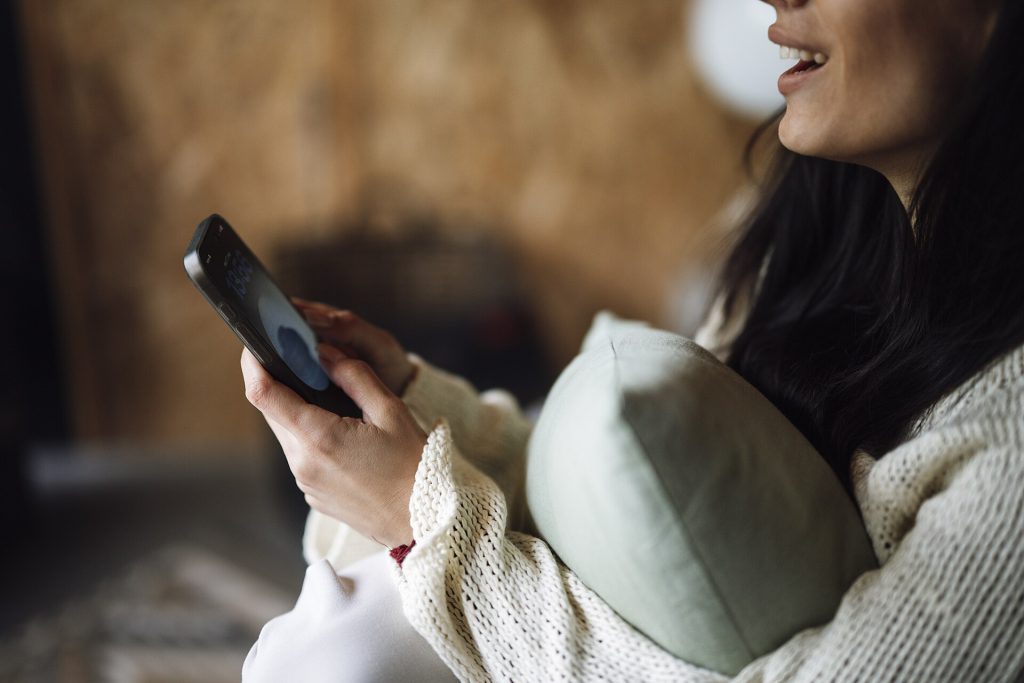 Woman sitting at home checking information on her smartphone